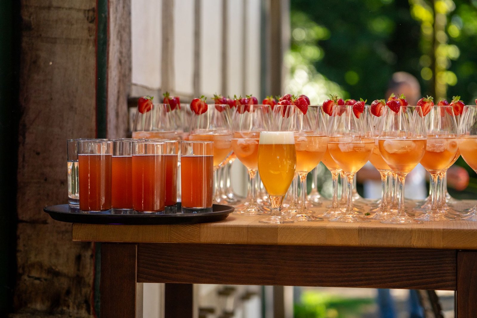Cocktails lined up on a bar at an outdoor event