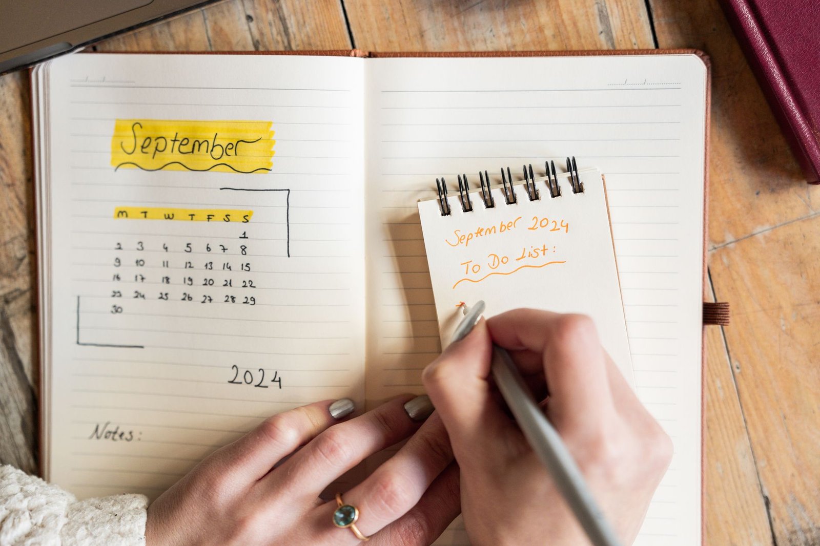 A notebook and calendar on a desk
